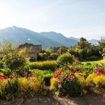 Der Blick schweift über fröhlich blühende Blumen- und Gemüsebeete bis zu den pittoresken Berner Voralpen.