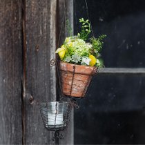 Stimmiges Chrüsimüsi: Das kalkbesetzte Tontöpfchen, das Rita Hadorn mit Blüten gefüllt hat, lässt sich in einer Drahtampel aufhängen oder als klassischer Tischschmuck verwenden.