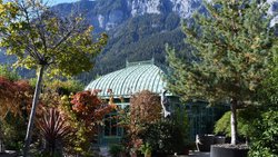 Filigranes Glashaus vor schroffer Felswand: Die Berge als Kulisse geben der Bühne – dem Garten – einen starken Ausdruck.