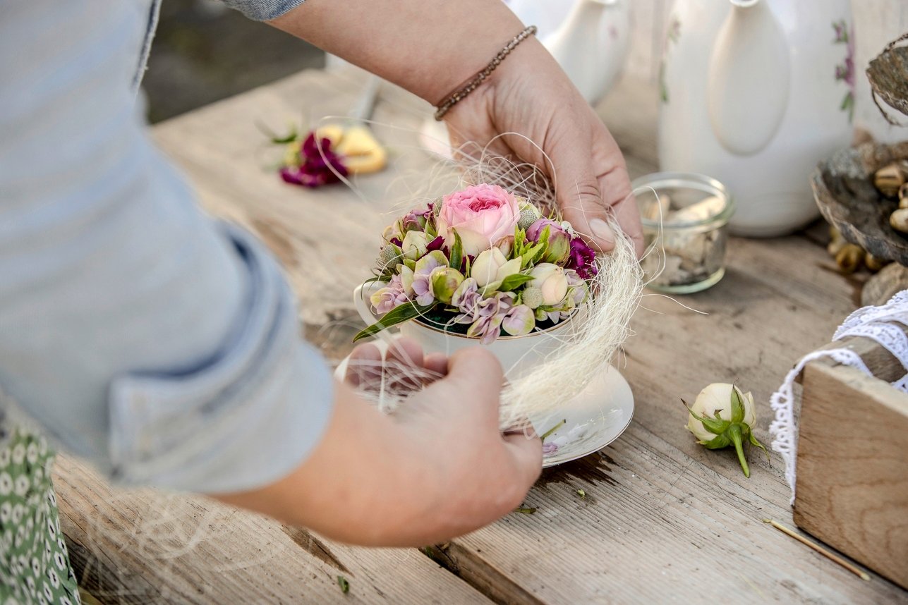 Sisalfäden um den Tassenrand und die Blumen schlingen