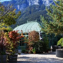 Filigranes Glashaus vor schroffer Felswand: Die Berge als Kulisse geben der Bühne – dem Garten – einen starken Ausdruck.
