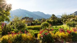 Der Blick schweift über fröhlich blühende Blumen- und Gemüsebeete bis zu den pittoresken Berner Voralpen.