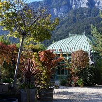 Filigranes Glashaus vor schroffer Felswand: Die Berge als Kulisse geben der Bühne – dem Garten – einen starken Ausdruck.